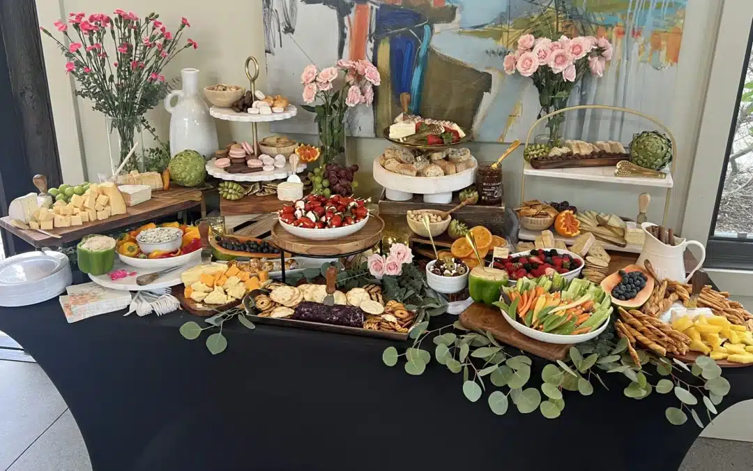 Multi-dimensional grazing table by Fork and Flare in Orange County featuring an abundant display of crudités, mixed berries, grapes, kiwi, blood oranges, caprese skewers, olive tapenade, hummus, spinach and artichoke dip, fresh bread, mixed nuts, and an array of cheeses including goat, brie, manchego, gouda, and cheddar, perfect for weddings, upscale parties, and corporate events.